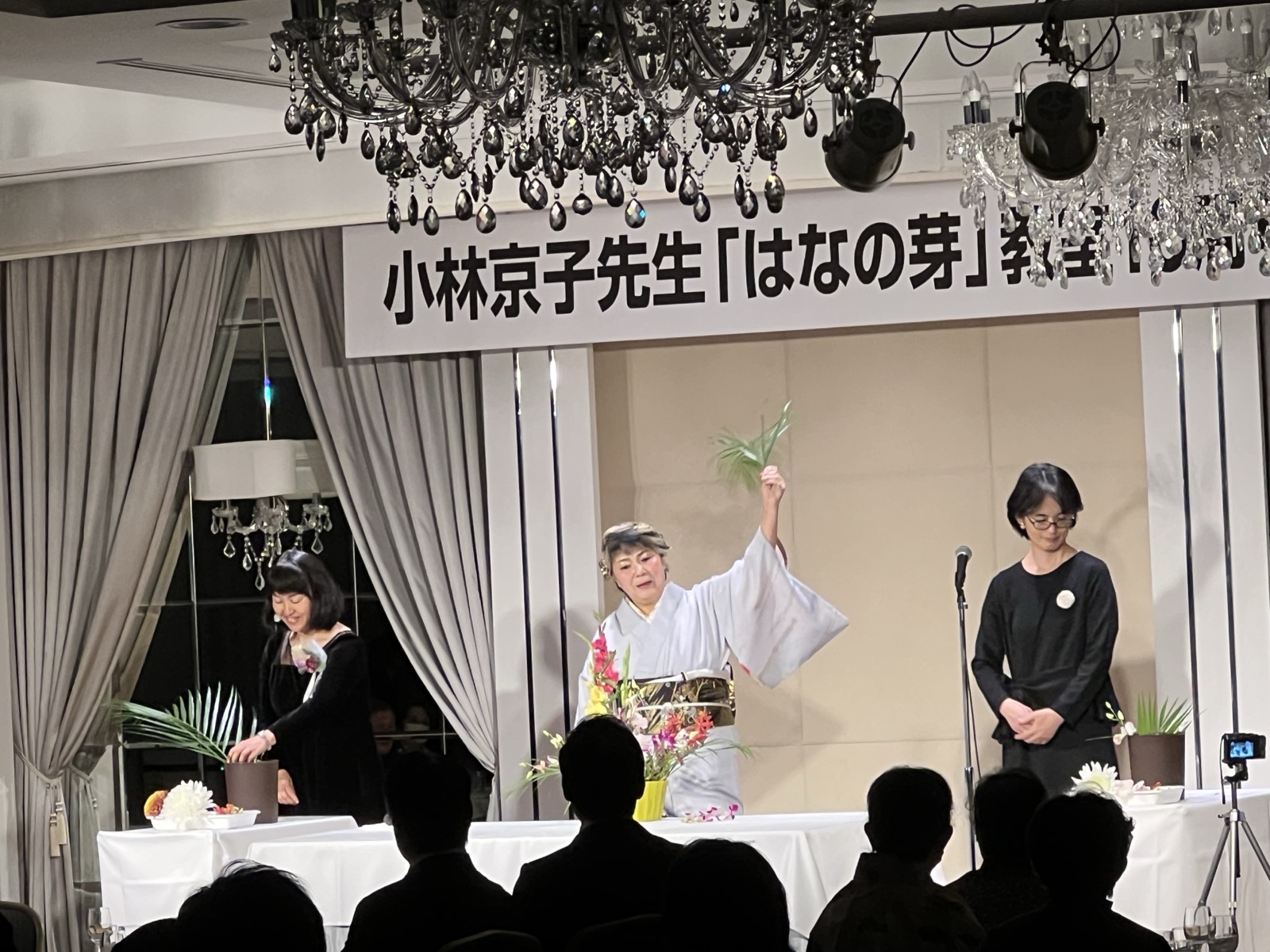 10周年パフォーマンスいけばな ── 看板の下で花を活ける小林京子先生